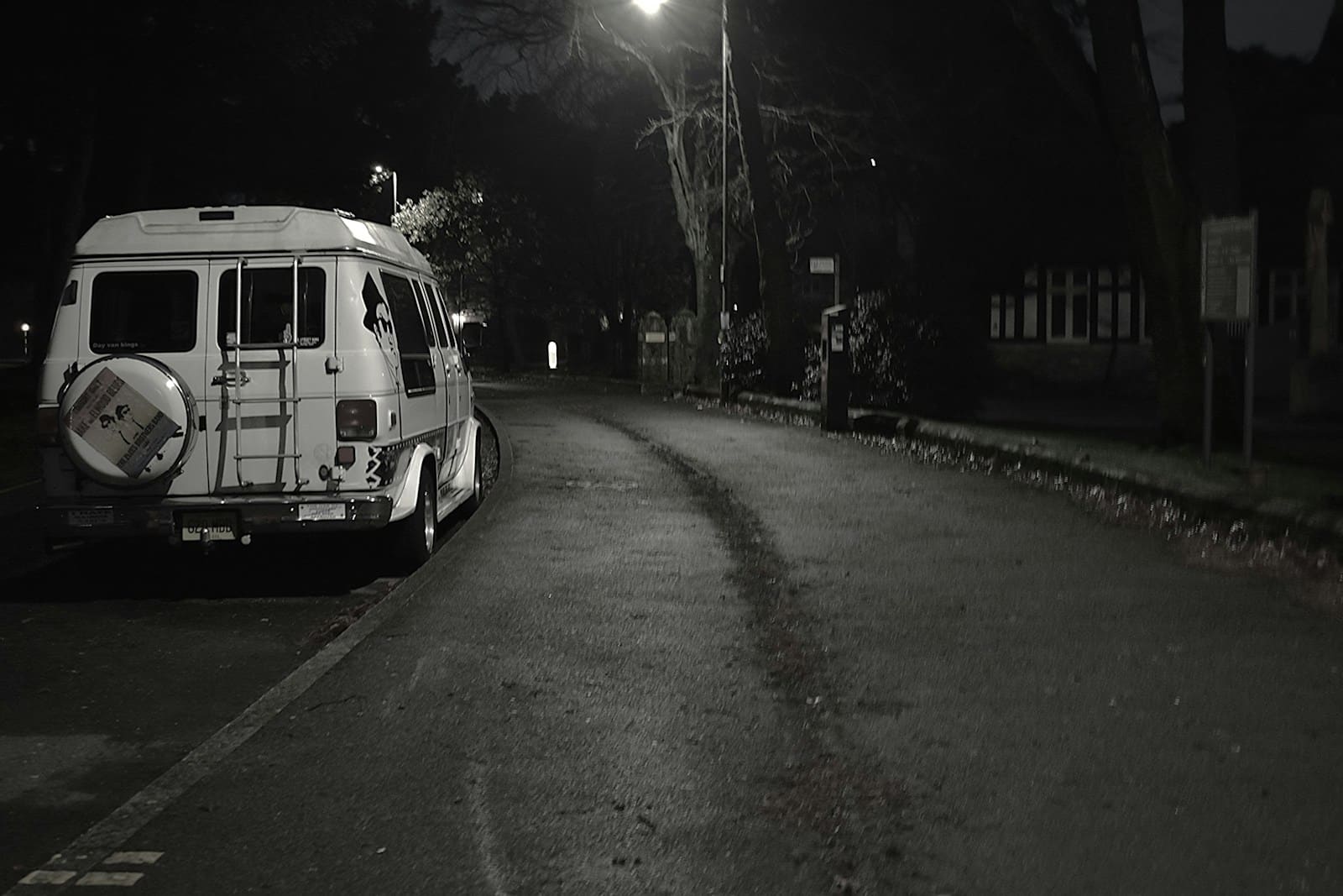 A van parked on the side of a road at night