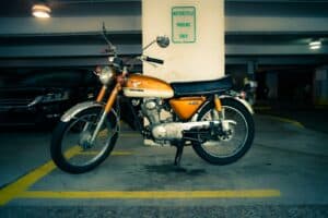 person taking photo of orange Honda standard motorcycle