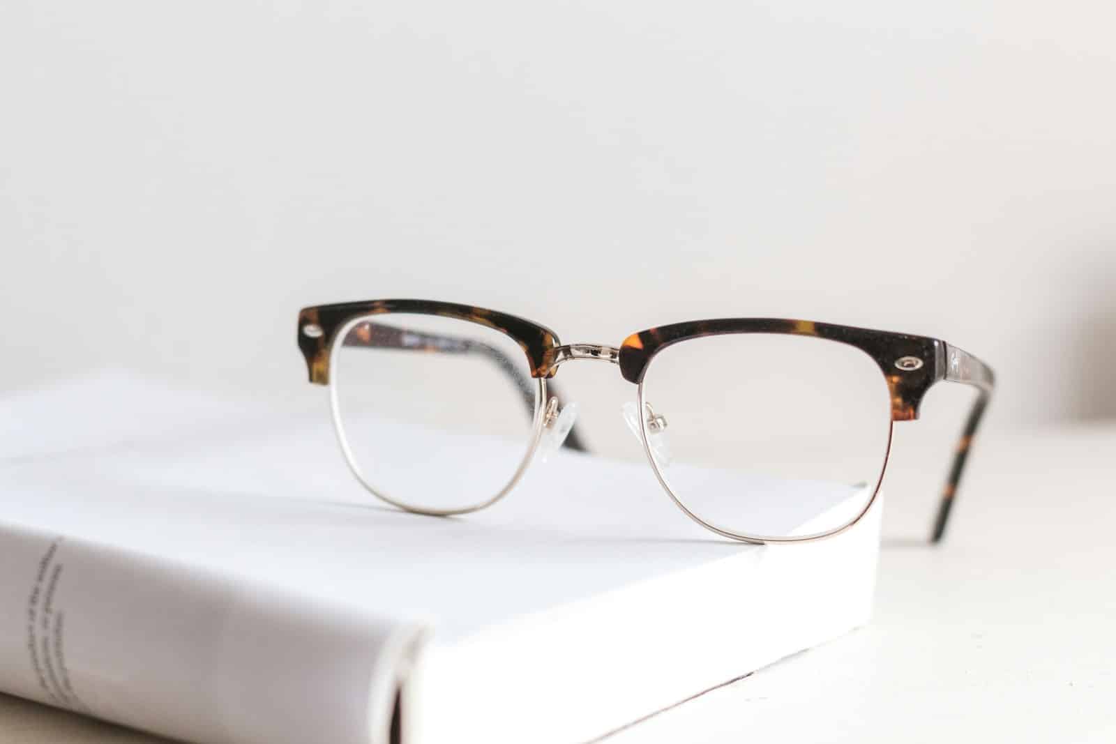 Paire de lunettes cassées posée sur une table en bois
